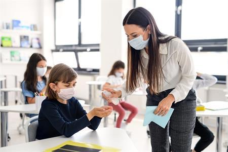 Alunna e insegnante in classe con mascherina