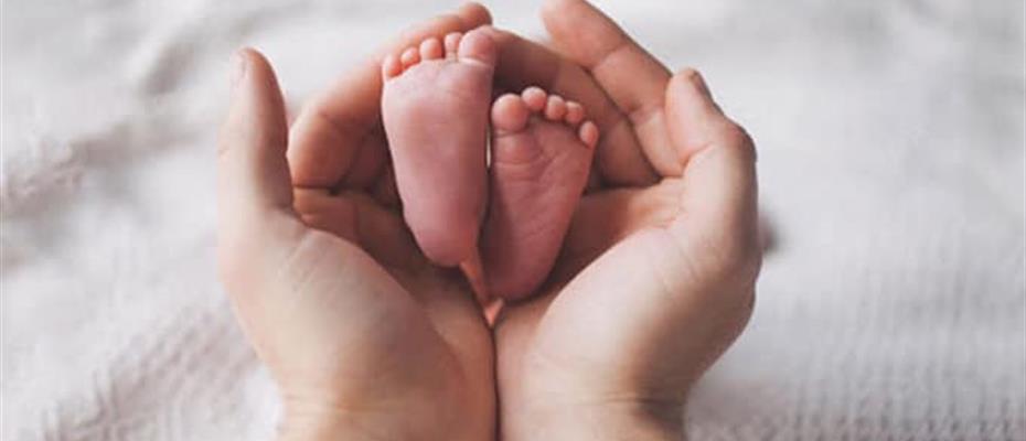 Mani adulte con piedini di bimbo