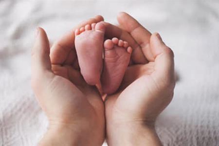 Mani adulte con piedini di bimbo